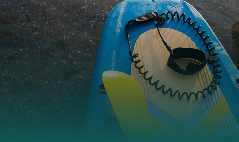 Surfboard with leash on wet surface.