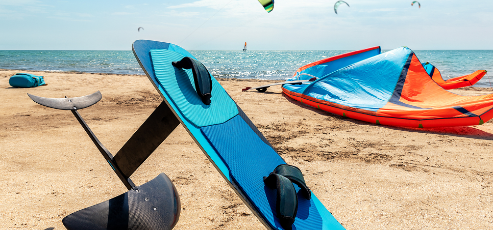 Kitesurfing gear on a sandy beach.